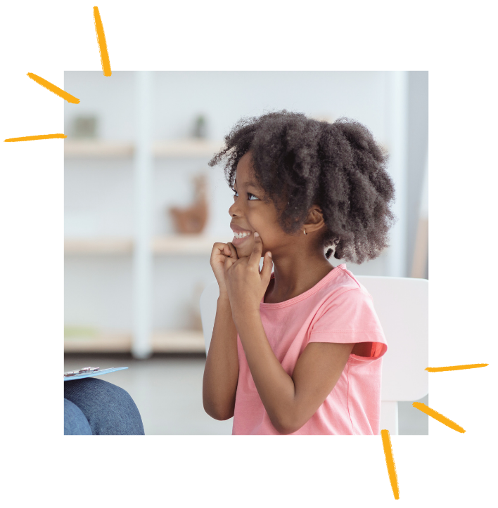 A young child wearing a pink shirt with coily hair is holding her mouth up with her fingers while receiving a speech therapy evaluation to assess her speech present levels